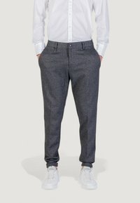 Pantaloni in misto lana grigi con vestibilità su misura, dotati di tasche frontali, chiusura con bottone e sneakers bianche per un look casual.