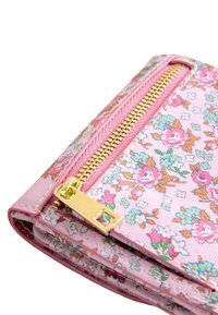 Portefeuille en tissu floral rose, avec une fermeture éclair dorée et des éléments en métal. Fabriqué en matériau texturé avec plusieurs compartiments pour le rangement.