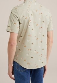 Košile s krátkým rukávem z jemně zelené látky s květinovým a abstraktním vzorem, s kulatým lemem košile a límcem na knoflíky.