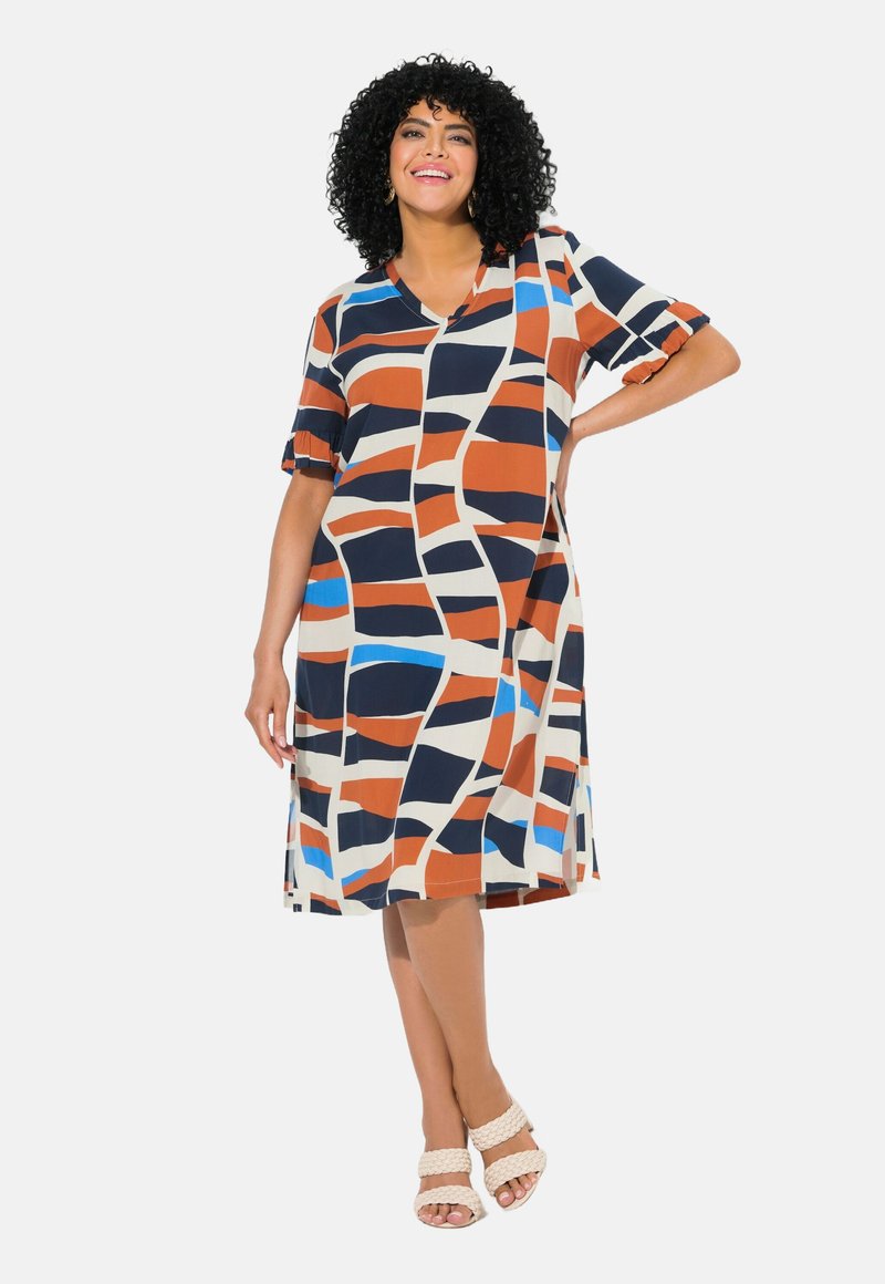 Lyhythihainen mekko kevyestä kankaasta, jossa on geometrinen kuvio oranssina, laivastonsinisenä, beigenä ja sinisenä. V-mallinen kaula-aukko ja röyhelöhihat.