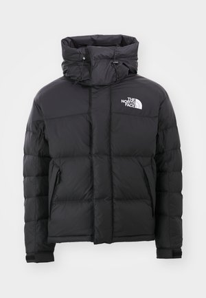 Chaqueta acolchada negra con cuello alto, frontal con cremallera y un logotipo bordado en la parte superior izquierda. Cuenta con secciones acolchadas y puños elásticos.