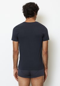 Donkerblauwe T-shirt met korte mouwen en een getailleerd ontwerp, gemaakt van zacht materiaal, met een ronde hals en een gladde textuur.