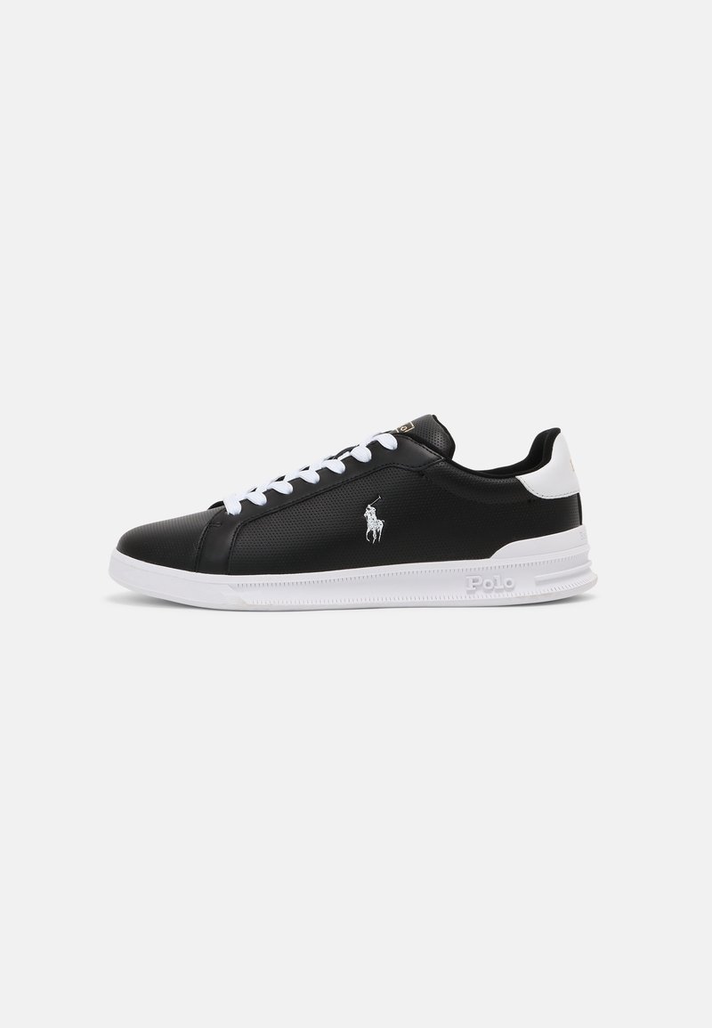 Baskets basses noir et blanc avec lacets blancs, cuir perforé, logo Polo sur le côté et semelle blanche avec adhérence texturée.