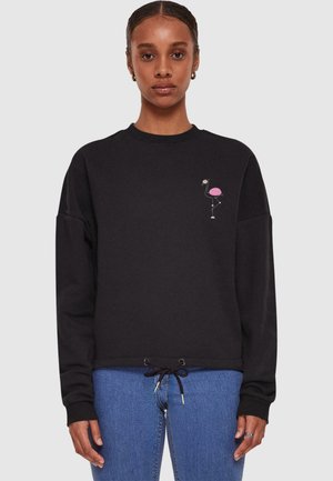 Black sweatshirt with a pink flamingo design on the left chest, featuring a round neck and adjustable drawstring at the waist.