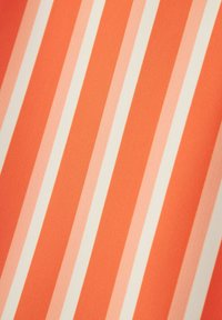 Rayas diagonales en tonos de naranja y blanco formando un patrón repetido sobre una superficie de tela suave.