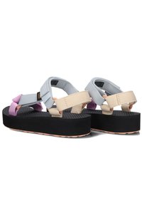 Sandalias de plataforma con suela de goma negra, que presentan correas de nailon en gris, beige y lavanda con un diseño entrelazado. Plantilla texturizada.