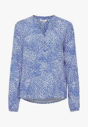 Sininen pitkähihaisen paita, jossa on valkoisia pilkkuja, V-pääntie ja napitus, valmistettu kevyestä kankaasta.