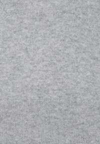 Helle graue Strickware mit einer subtilen Textur und gleichmäßigem Muster, mit gerippten Kanten am unteren Ende. Weiches und flexibles Material.