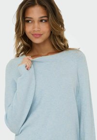 Light blue sweater with a wide neckline and long sleeves. The soft, textured fabric features ribbed accents at the neckline and cuffs.