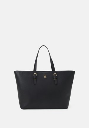 Czarna skórzana torba na ramię z podwójnymi paskami i małym złotym logo umieszczonym na środku przodu.