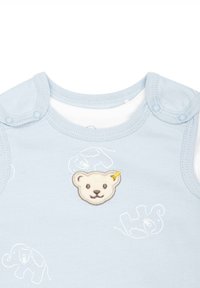 Hellblaues, ärmelloses Baby-Bodysuit mit Druckknöpfen, versehen mit einem Bärenapplikation und schwachen Mustern von Elefanten und Löwen auf dem Stoff.