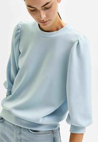 Light blue sweatshirt with puffed sleeves, ribbed cuffs and hem, made from soft fabric, featuring a round neckline and minimalistic design.