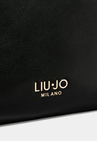 Čierna kožená taška s textúrou, ktorá obsahuje zlaté embosované logo "LIU•JO MILANO." Zameranie na štýlový dizajn a prémiový materiál.