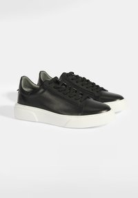 Schwarze Leder-Sneaker mit strukturiertem Finish, Schnürdesign und einer weißen Gummisohle mit leichtem Plateau. Glatte Innenauskleidung.