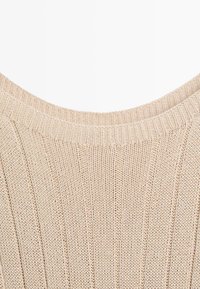 Beige knitted sweater neckline with ribbed collar and vertical textured stitch pattern.