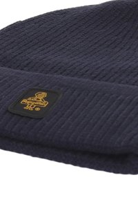 Berretto lavorato a maglia blu navy realizzato in tessuto testurizzato; presenta una toppa con logo nero e scritta dorata sulla parte anteriore. Stile con risvolto.