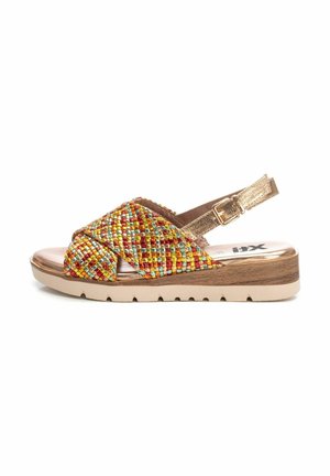 Sandalias multicolores tejidas con una correa metálica dorada, una plantilla acolchada y una suela beige estriada. Diseño cruzado en la parte superior.