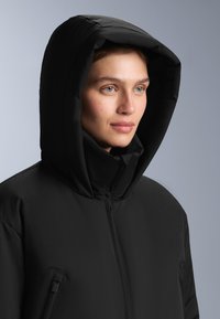 Czarna pikowana kurtka z wysokim kołnierzem i dużym kapturem, charakteryzująca się nowoczesnym designem i przednim zamkiem błyskawicznym. Gładka, matowa tekstura.