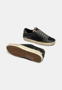 Sneaker nere in pelle con accenti grigi, suola in gomma testurizzata e punta piatta. Presentano lacci rotondi e dettagli del logo sui lati.