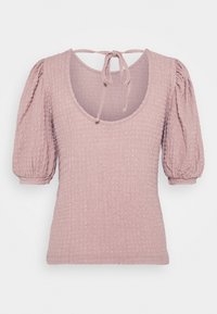Haut texturé mauve clair avec manches bouffantes jusqu'aux coudes et encolure dégagée avec fermeture à nouer au dos.