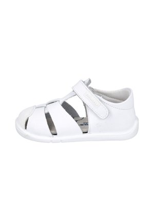 Sandalia blanca para niño pequeño con talón cerrado, puntera abierta y correa ajustable de Velcro sobre el empeine para un ajuste seguro.