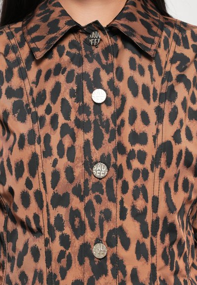 Prindi leopardi mustris nööpidega särk pruunis ja mustas, millel on metallist logoga nööbid, klassikaline krae ja sile tekstuur.
