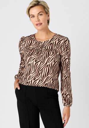 Langärmlige Bluse in Hellbraun mit dunkelbraunen Zebramustern, mit rundem Ausschnitt und gerafften Details an den Schultern.