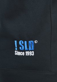Čierna mikina s výšivkou v svetlomodrej a bielej farbe. Text obsahuje "! SLD ©" a "Od roku 1993." Mäkko bavlnené zloženie.