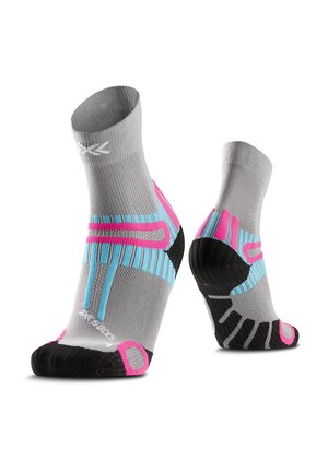 Paar grijze atletische enkelsokken met zwarte zolen en roze en blauwe ondersteuningsstrepen, rechtop weergegeven op een witte achtergrond.