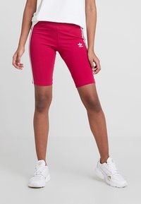 Rosa idrottshorts i stretchigt material med kontrasterande vita sidostrecker och en Adidas-logotyp på vänster ben, i skräddarsydd passform.