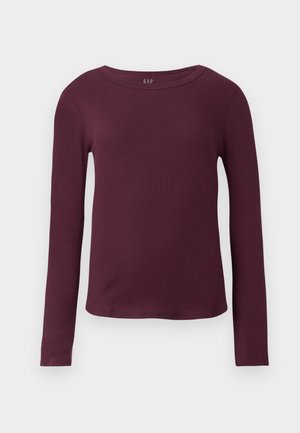 Haut bordeaux à manches longues en matière côtelée avec un col rond et une silhouette ajustée. Dispose d'une étiquette avec le logo "GAP" au niveau du col.