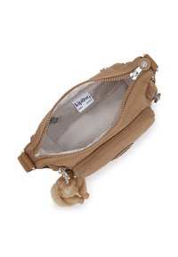 Sacco in tessuto beige con doppia cerniera, fodera in cotone e un charm peloso. Presenta un'etichetta con il logo e dettagli testurizzati lungo la cerniera.