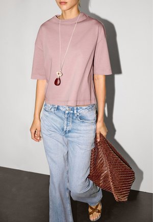 Vaaleanpunainen lyhyt t-paita, väljät siniset farkut, ruskea punottu käsilaukku ja kaulakoru, jossa on soikea punainen kivi. Täydellinen tyyli litteillä sandaleilla.