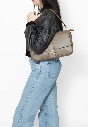 Borsa a spalla in pelle beige con finitura testurizzata, hardware in oro e una tracolla in tonalità marrone. La borsa presenta una patta frontale e cuciture decorative.