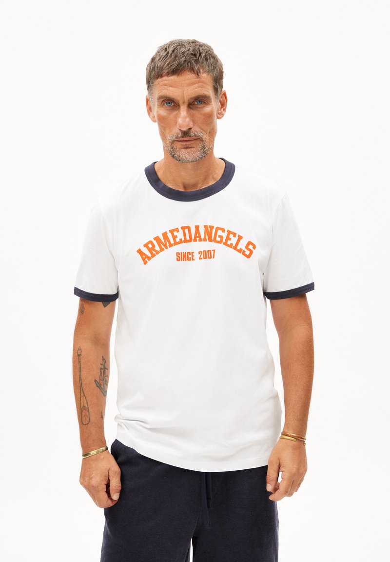 Witte katoenen t-shirt met een marineblauwe geribbelde kraag en mouwen, met de tekst "ARMEDANGELS" en "SINCE 2007" in oranje letters op de voorkant.