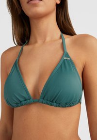 Teal driehoek bikini-top gemaakt van zachte stof, met geplooide details en een metalen logo-accent in het midden, met halternekbandjes.