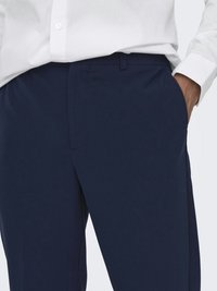 Marinblå byxor i slät tygkvalitet, med slim fit, sidofickor och sydd midja med en diskret stängning.