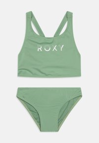Grünes Bikinitop-Set mit Racerback-Oberteil und "ROXY"-Logo in Weiß. Glattes Gewebe mit weicher Textur, ideal für Badebekleidung.