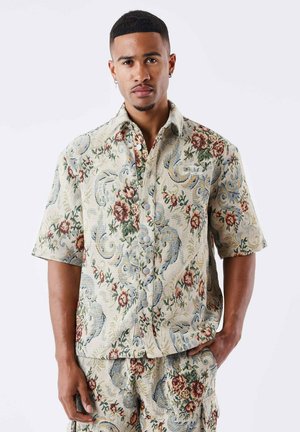 Korte mouw shirt met een bloemenpatroon in beige, blauw en rode tinten, met lichte knopen en een relaxte pasvorm.