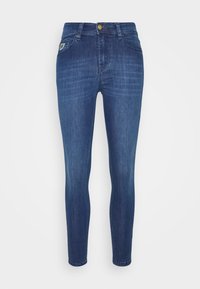 Slim jeans i mörkblå denim, med fem fickor, guldknappsstängning och subtila blekningsdetaljer. Slät textur med en åtsittande design.