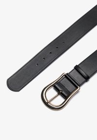 Zwarte leren riem met een gladde textuur, voorzien van een ronde goudkleurige gesp en verschillende verstelgaatjes langs de band.