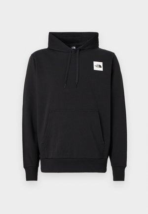 Musta puuvillasekoitevetoketjullinen huppari, jossa etutasku, säädettävä huppu ja pieni valkoinen logo rinnassa.