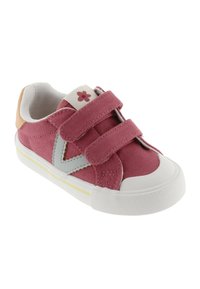 Sneaker in tela rosa con cinturini in velcro, suola in gomma bianca, accenti grigi e un piccolo dettaglio floreale sulla linguetta. Superficie in tessuto testurizzato.