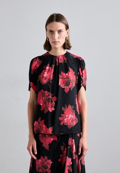 Bluză scurtă cu mâneci, de culoare neagră, cu model floral și trandafiri roșii, cu guler strâns și textură moale, asortată cu o fustă care se potrivește.