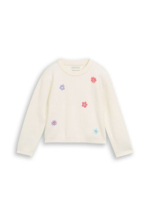 Pull à manches longues couleur crème avec des fleurs colorées brodées en violet, rouge, rose et bleu dispersées sur le devant.
