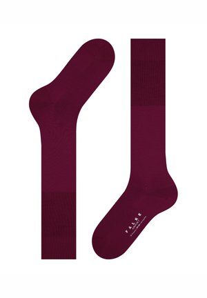 Paar dunkelburgunderfarbene knielange Socken, eine flach ausgelegt und die andere mit der Aufschrift "FALKE AIRPORT" auf der Sohle.