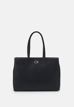 Černá kožená taška přes rameno s dvěma uchy, hladký povrch, zlaté logo "CK" na přední straně, minimalistický design, prostorný interiér.