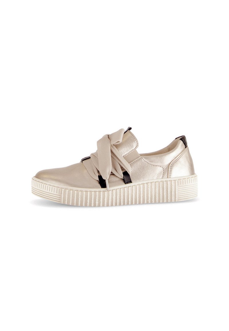 Buty z metaliczną, beżową cholewką ze skóry, zdobione tkaninową kokardą, z czarnymi akcentami oraz teksturowaną, białą gumową podeszwą z pionowymi rowkami.