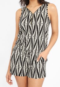 Černobílý overal se vzorem, s výstřihem do V, bočními kapsami a zipovým uzavíráním. Vyroben z lehkého materiálu s nastavitelným pasem na šňůrku.