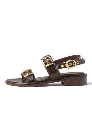 Sandalo in pelle marrone con due ampie fasce e dettagli con fibbie dorate, caratterizzato da un tacco basso a blocco in legno e cinturino alla caviglia con fibbia.